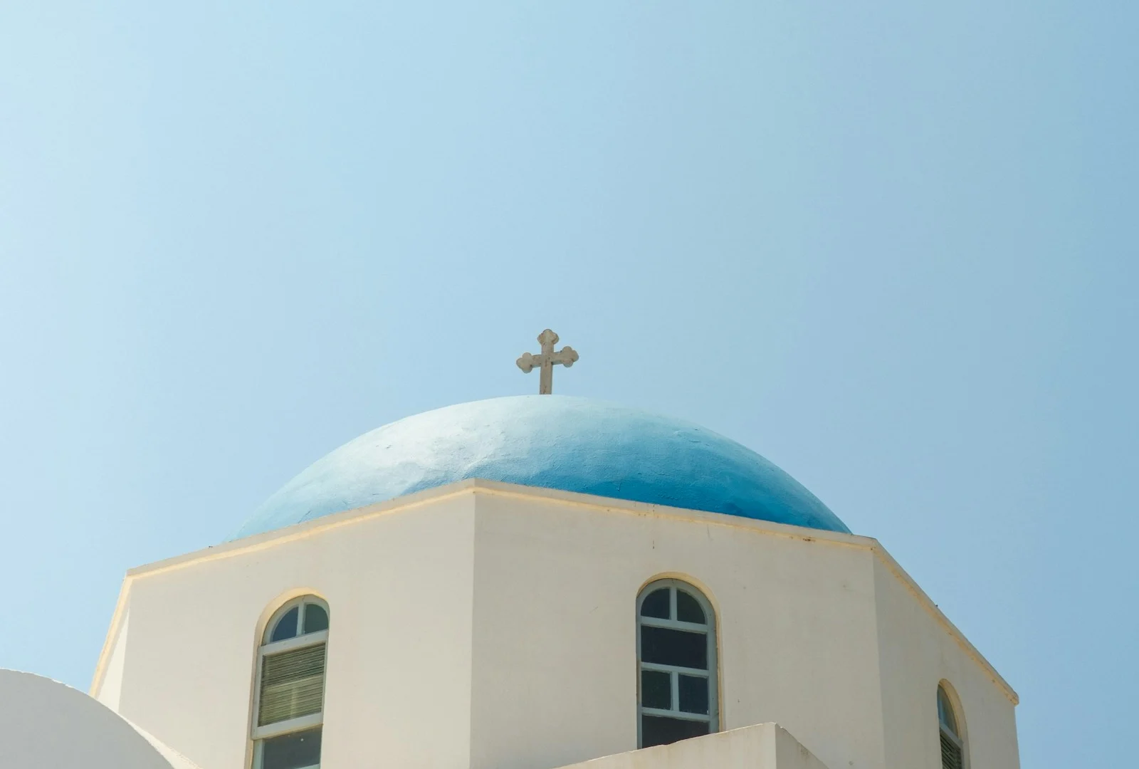 Blue-domed church beneath a clear sky in Paros